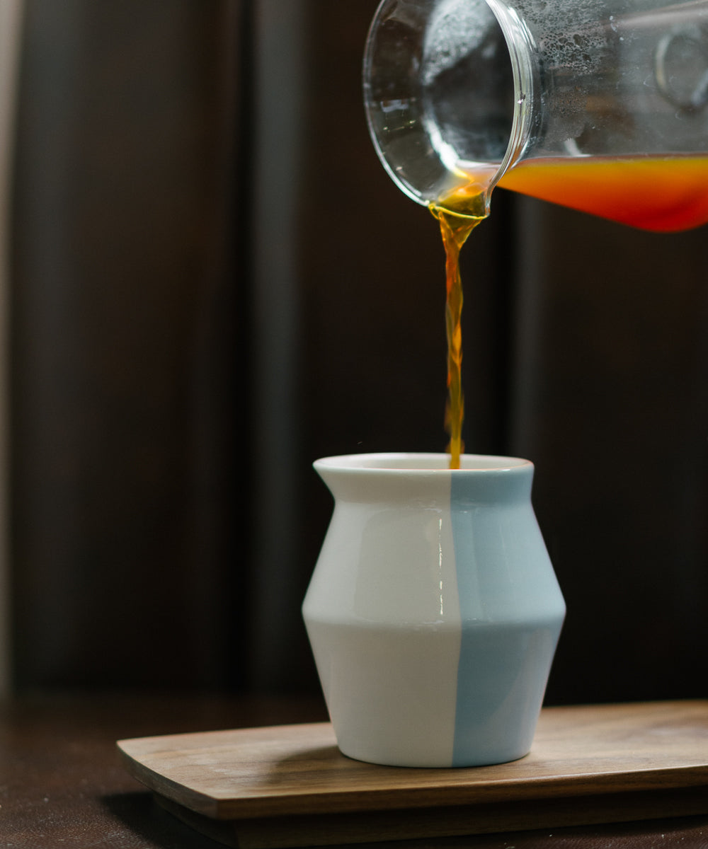 2-WayCup 330ml Refined Version ceramic tasting cup in the new blue glaze showing coffee poured into it from a carafe