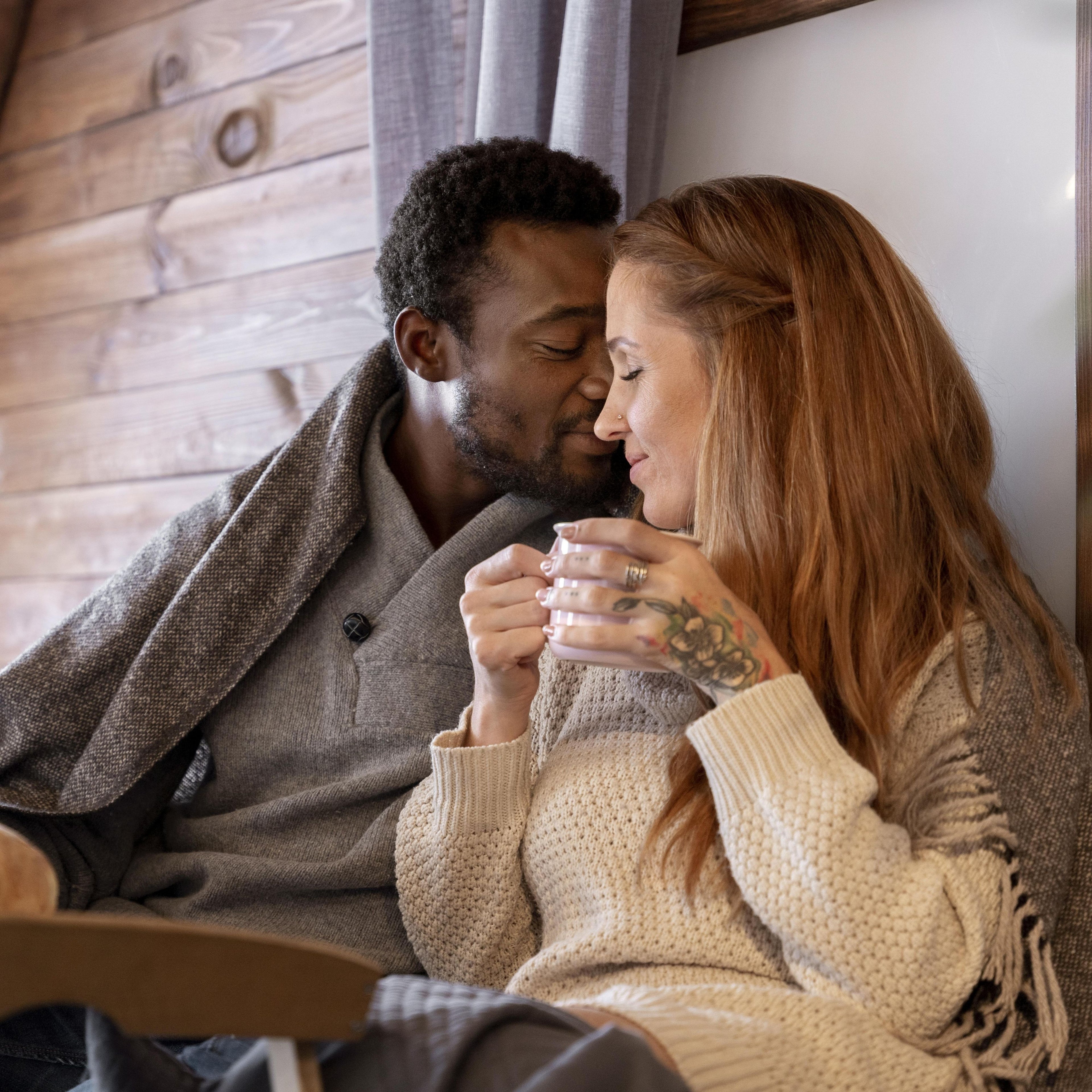 Couple in love luxuriating sitting close together, holding a mug of coffee, with a warm and cozy atmosphere. espresso momenti blog