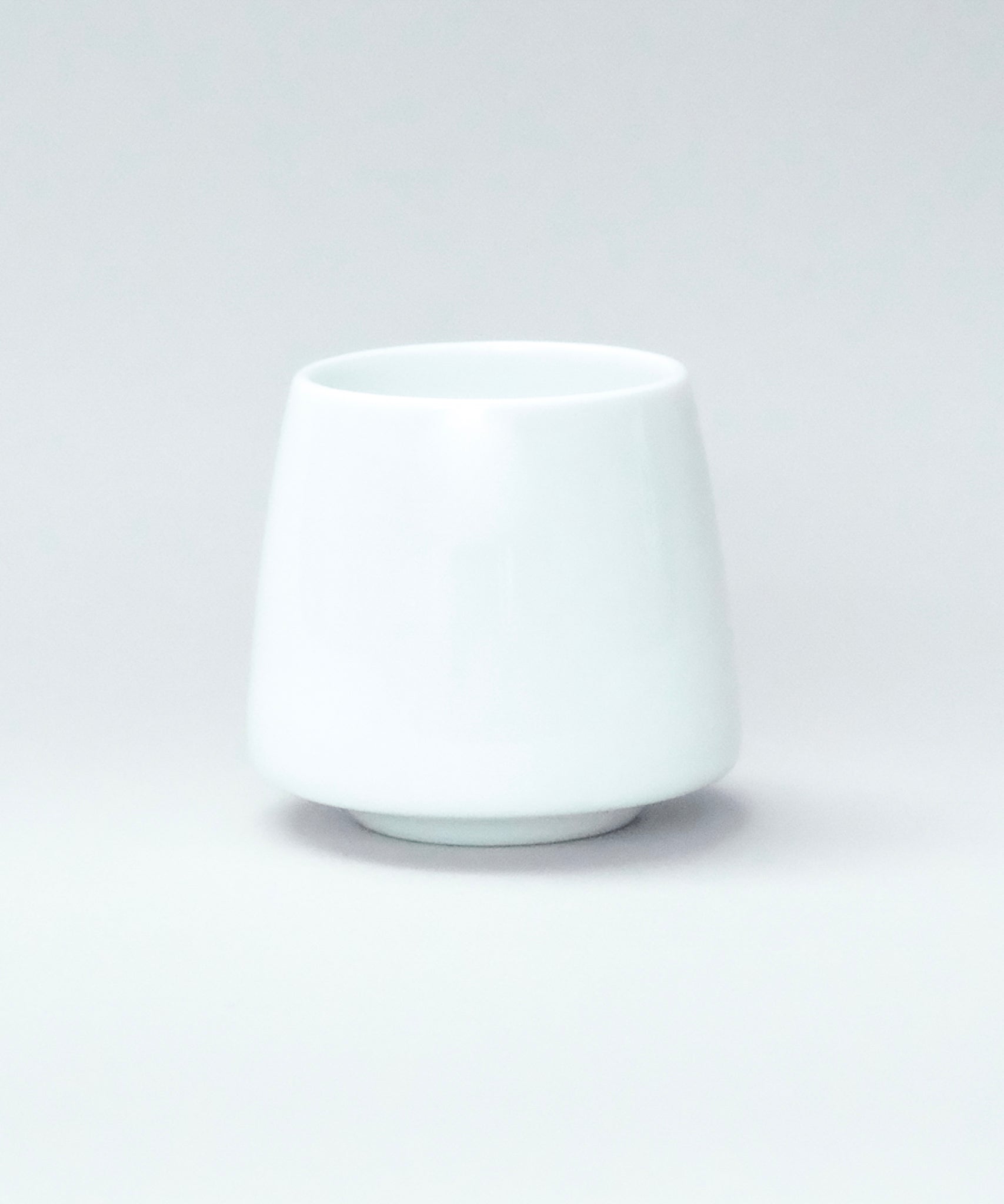 White origami aroma flavor ceramic cup on a light gray background