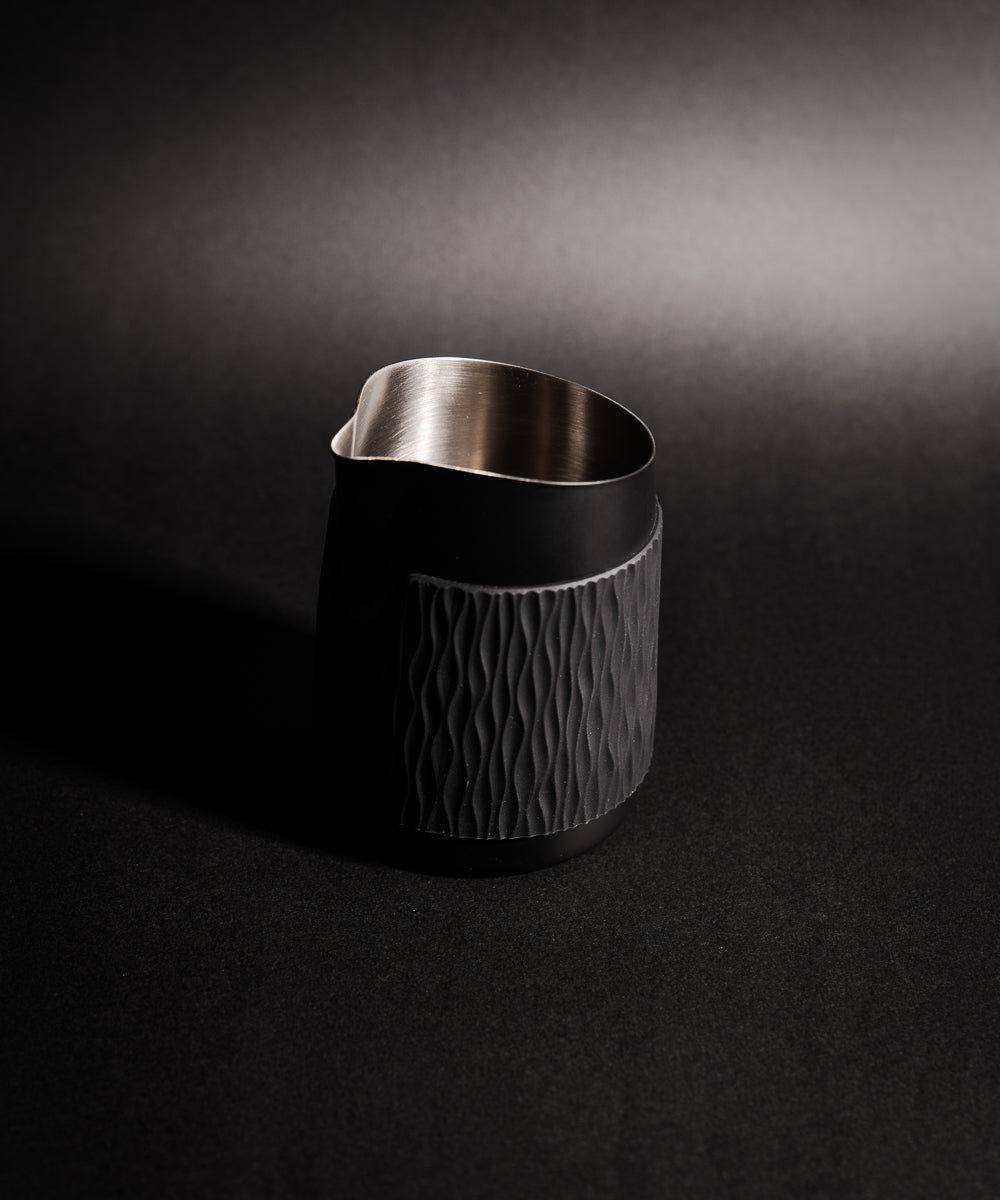 WPM Pitcher in Midnight Black shown from the side, featuring a sleek handleless design for latte art