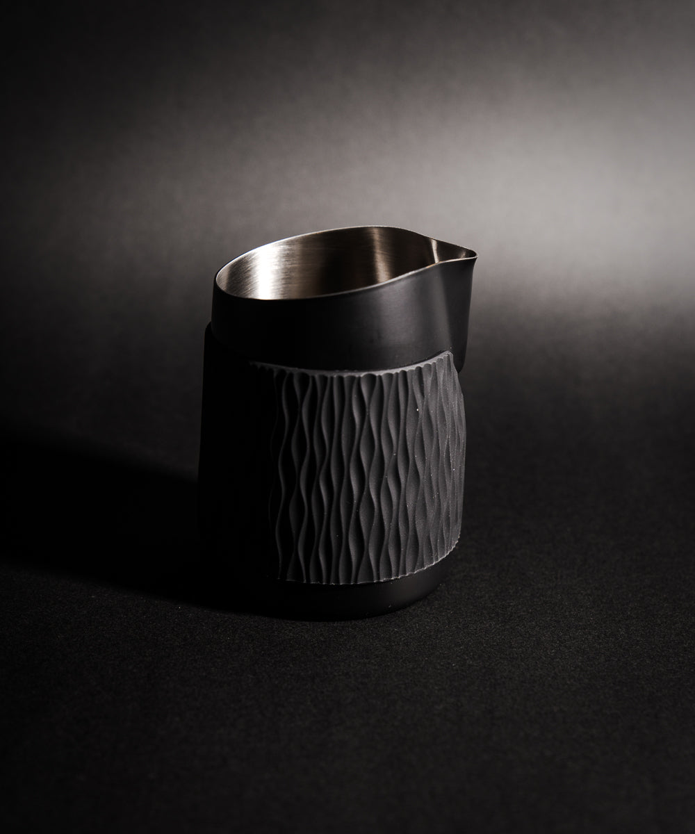 WPM Pitcher in Midnight Black shown from the side, featuring a sleek handleless design for latte art