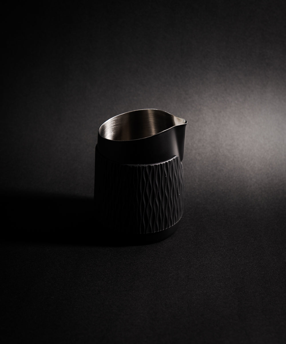 WPM Pitcher in Midnight Black shown from the side, featuring a sleek handleless design for latte art
