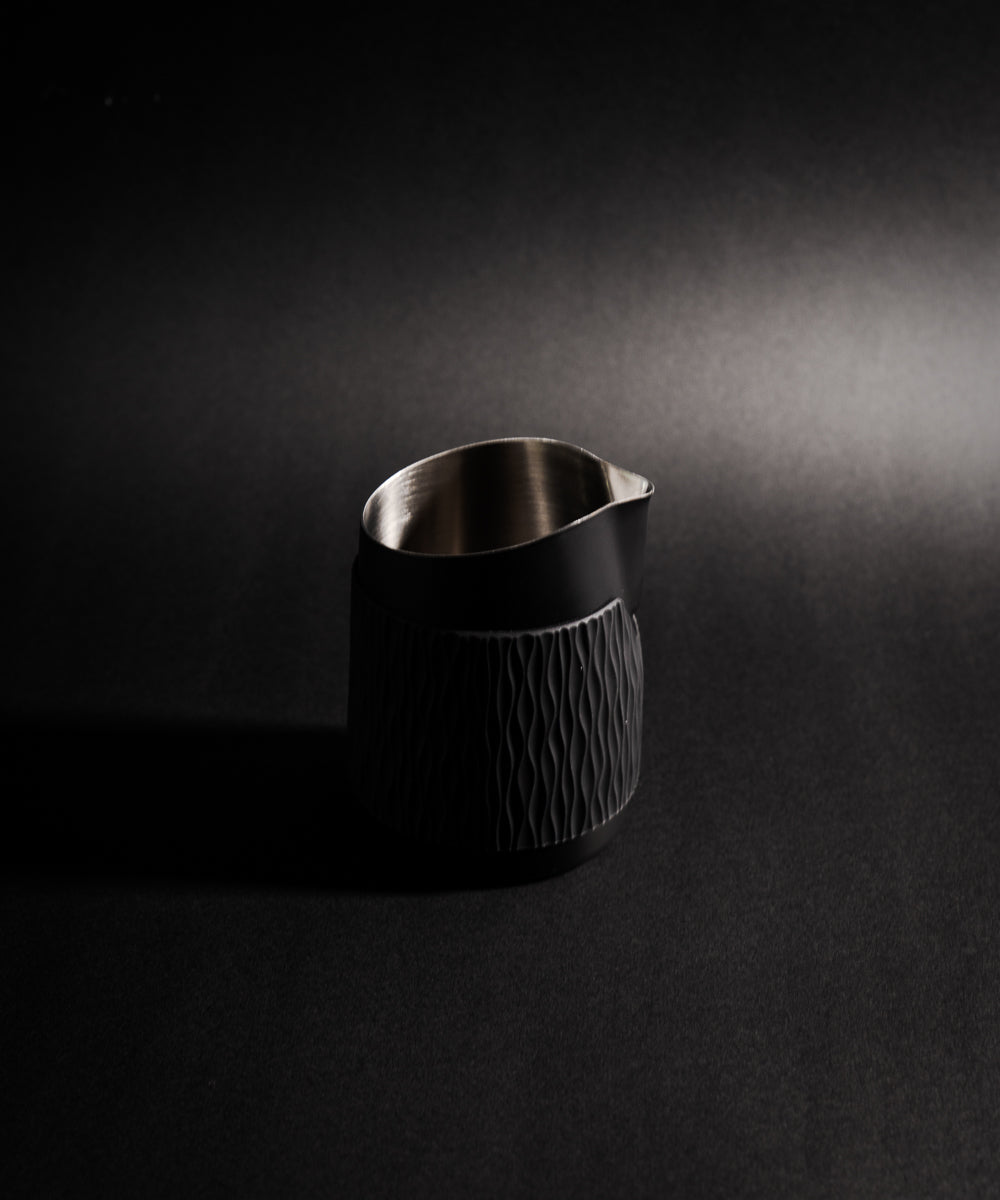 WPM Pitcher in Midnight Black shown from the side, featuring a sleek handleless design for latte art