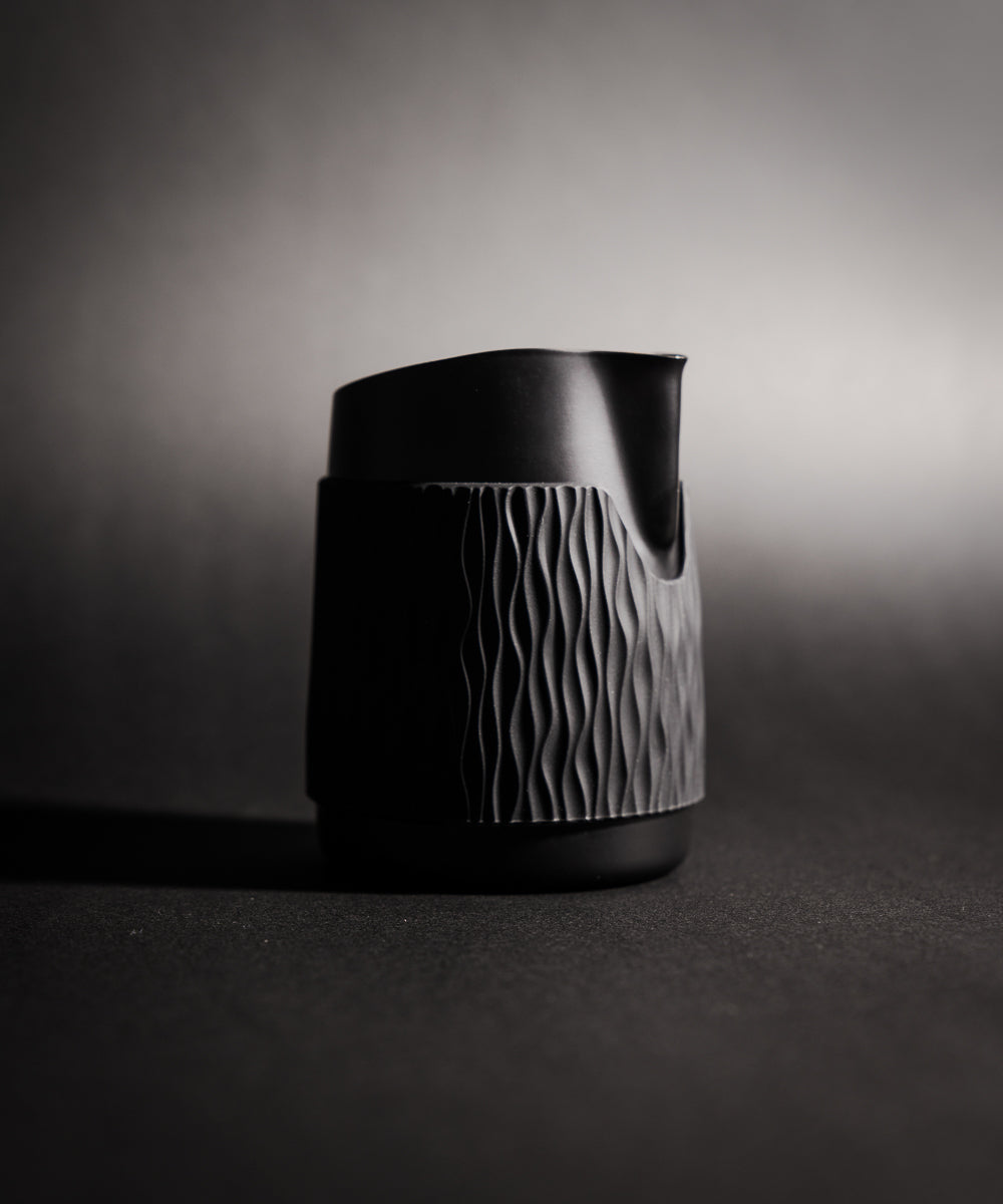 WPM Pitcher in Midnight Black shown from the side, featuring a sleek handleless design for latte art