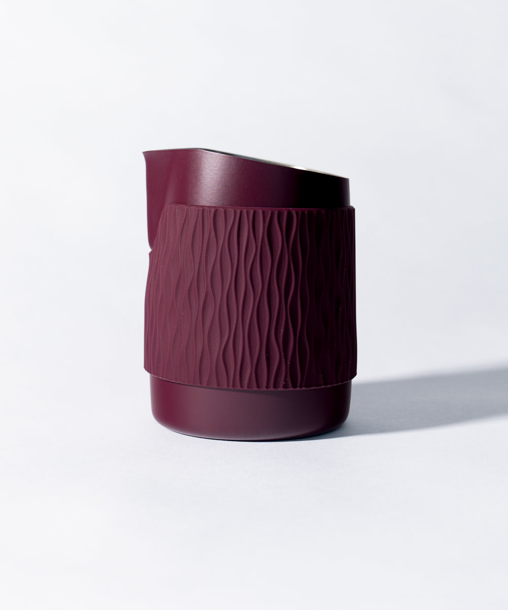 WPM Pitcher in Aubergine shown from the side, featuring a sleek handleless design for latte art