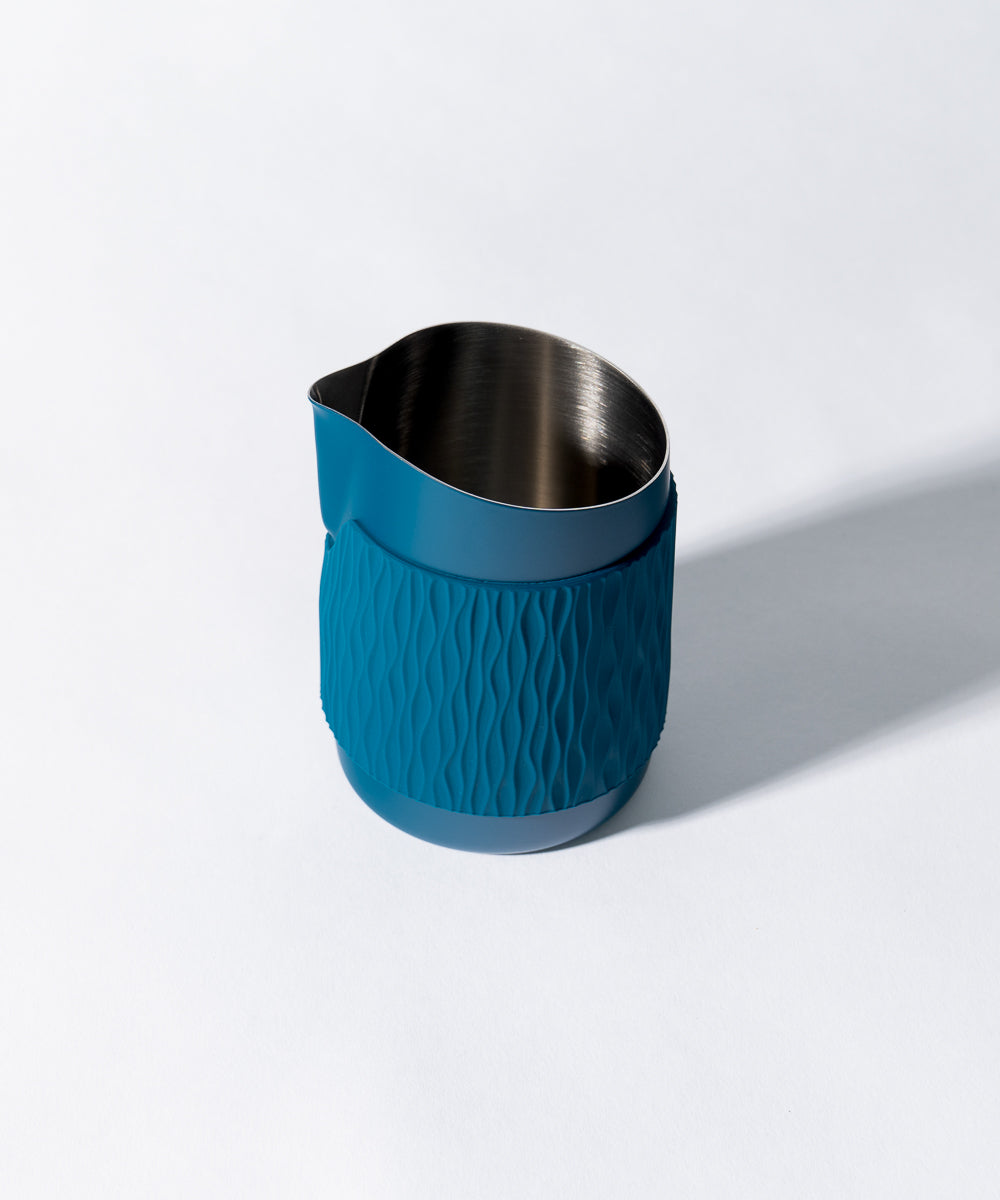 WPM Pitcher in Marina Blue shown from the side, featuring a sleek handleless design for latte art