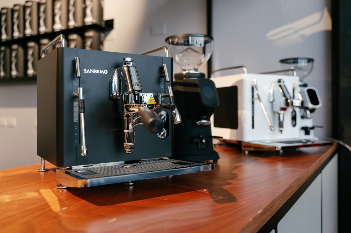Sanremo CUBE A R black home espresso machine and white B R sitting on wood counter with matching Fiorenzato Grinders
