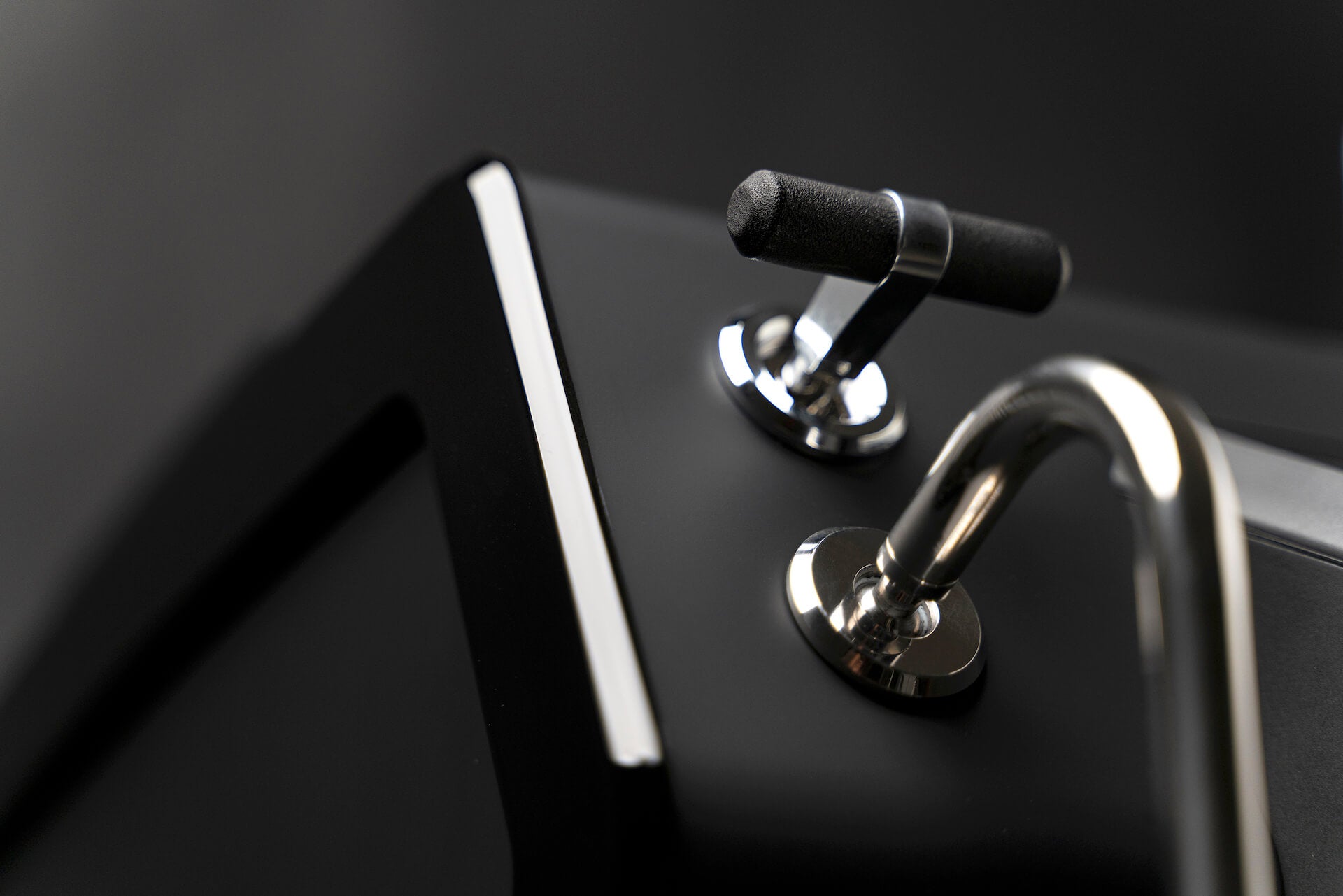  Sanremo YOU close-up of black hot water lever with chrome handles on a dark background
