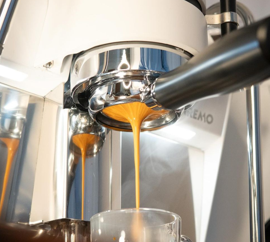 Sanremo YOU white home espresso machine prosumer professional close up Espresso being brewed into a clear glass from a 