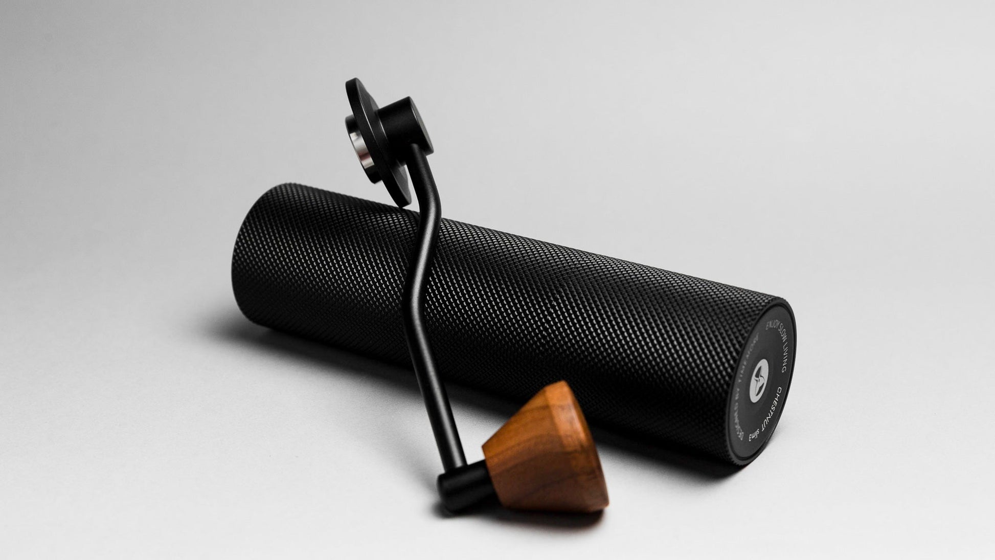 Black textured roller with wooden handle on a light gray background